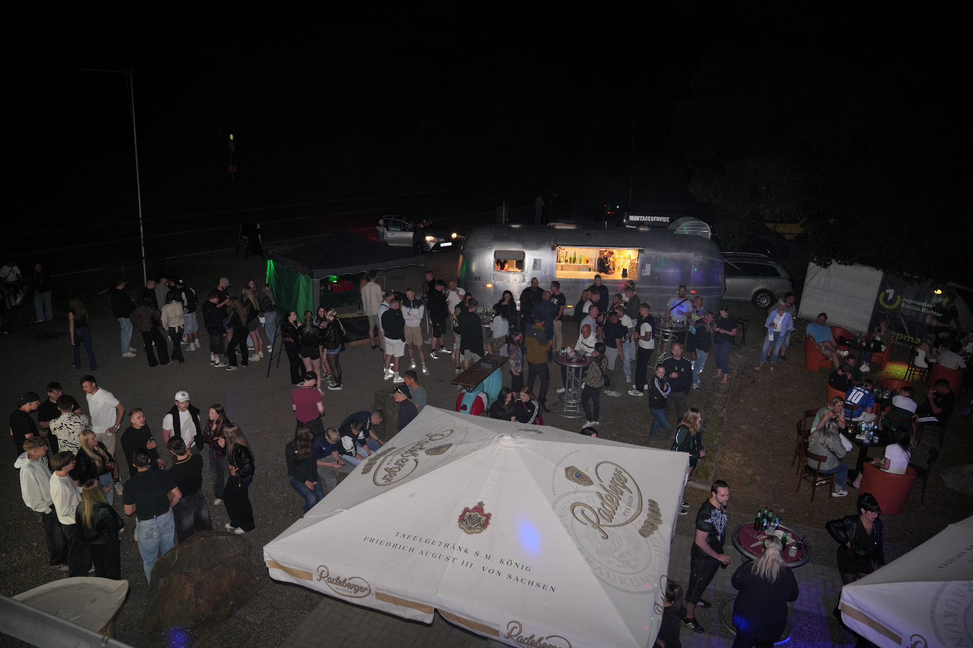 NEXUS Club Erzgebirge — Event bei Nacht mit Gästen, Airstream-Bar und Radeberger-Schirm